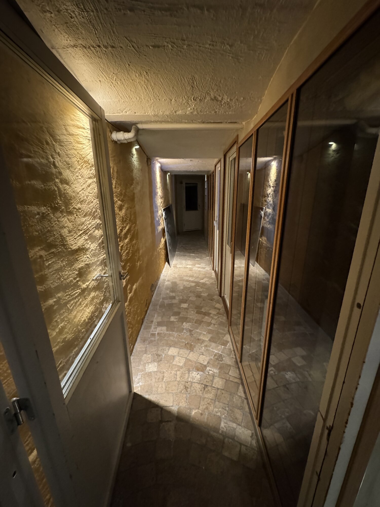 Stone-walled hallway connecting the studios